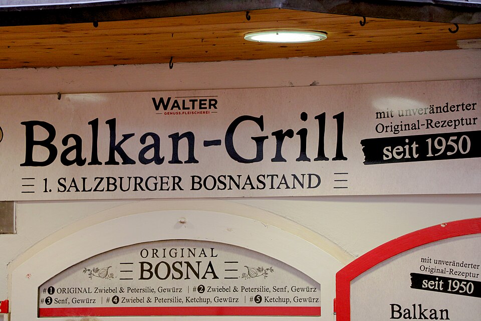 室內通道牆面上的紅白色招牌，大字寫著 Balkan-Grill WALTER，下方標示 1. SALZBURGER BOSNASTAND 與 ORIGINAL BOSNA seit 1950。